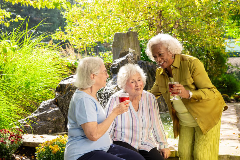 Three senior women talking on patio